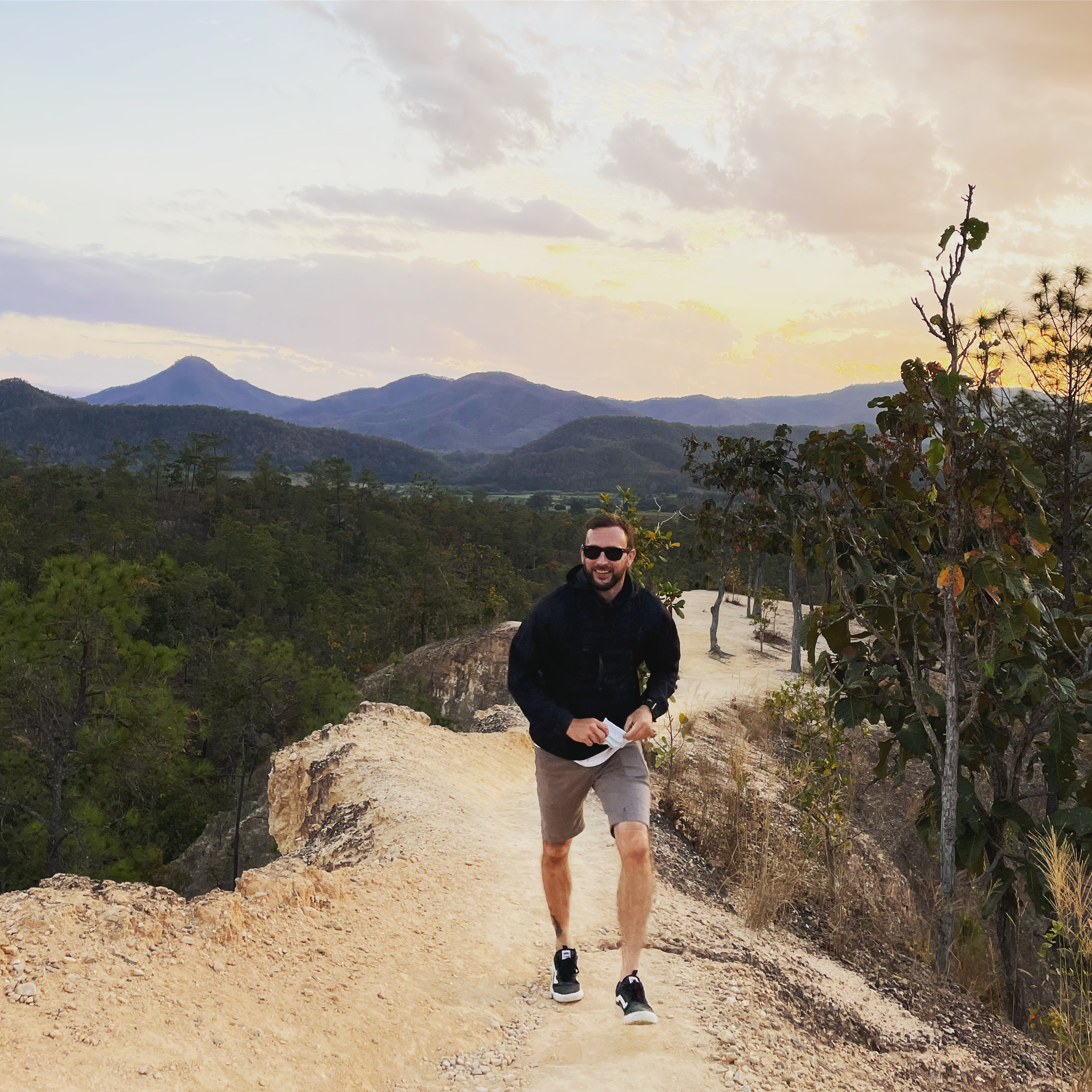 Chris walking a ridge trail at sunset in northern Thailand